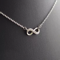 Végtelen szimbólum alakú ezüst medál cirkónia kövekkel, vékony ezüst láncon.
